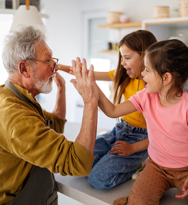 Grandfather with two children high fiving